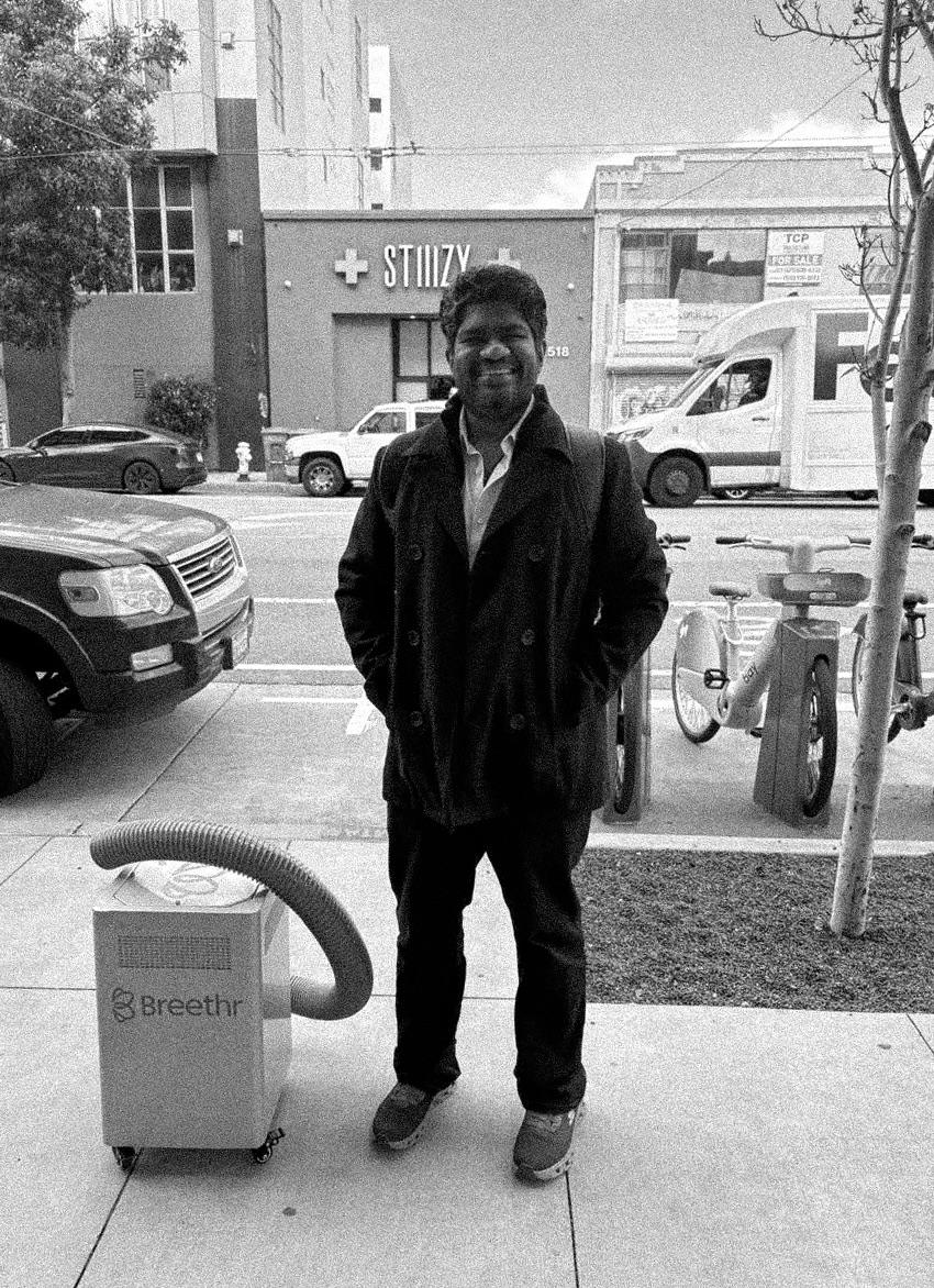 Abhinav Gupta standing on a San Francisco sidewalk beside a Breethr unit